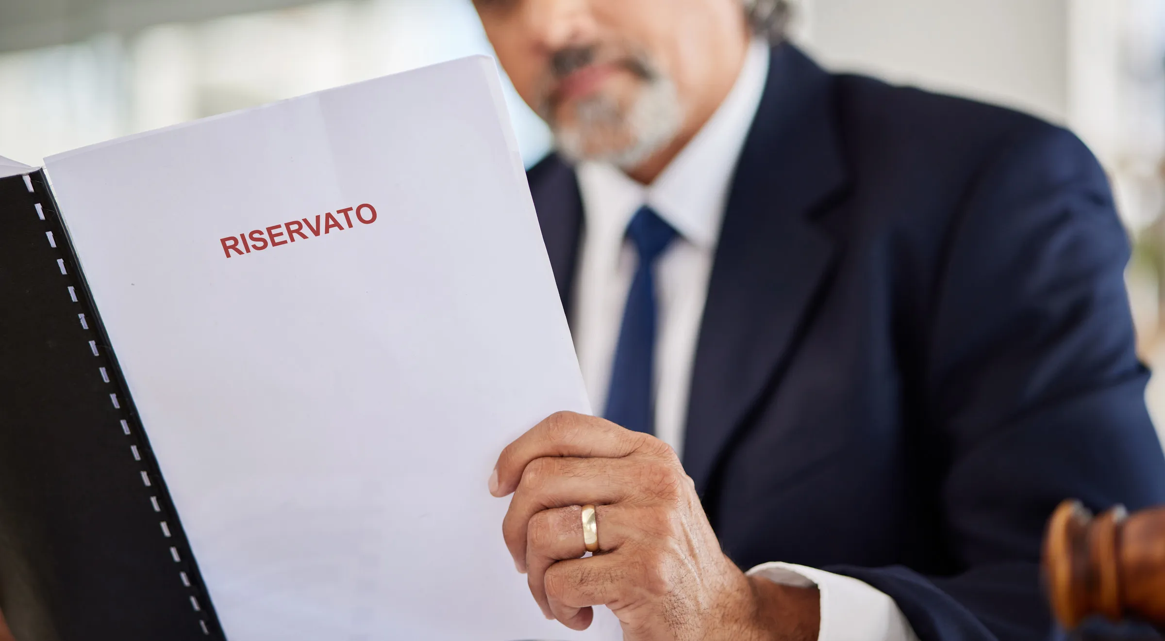 Professionista che legge un fascicolo con la scritta "Riservato"