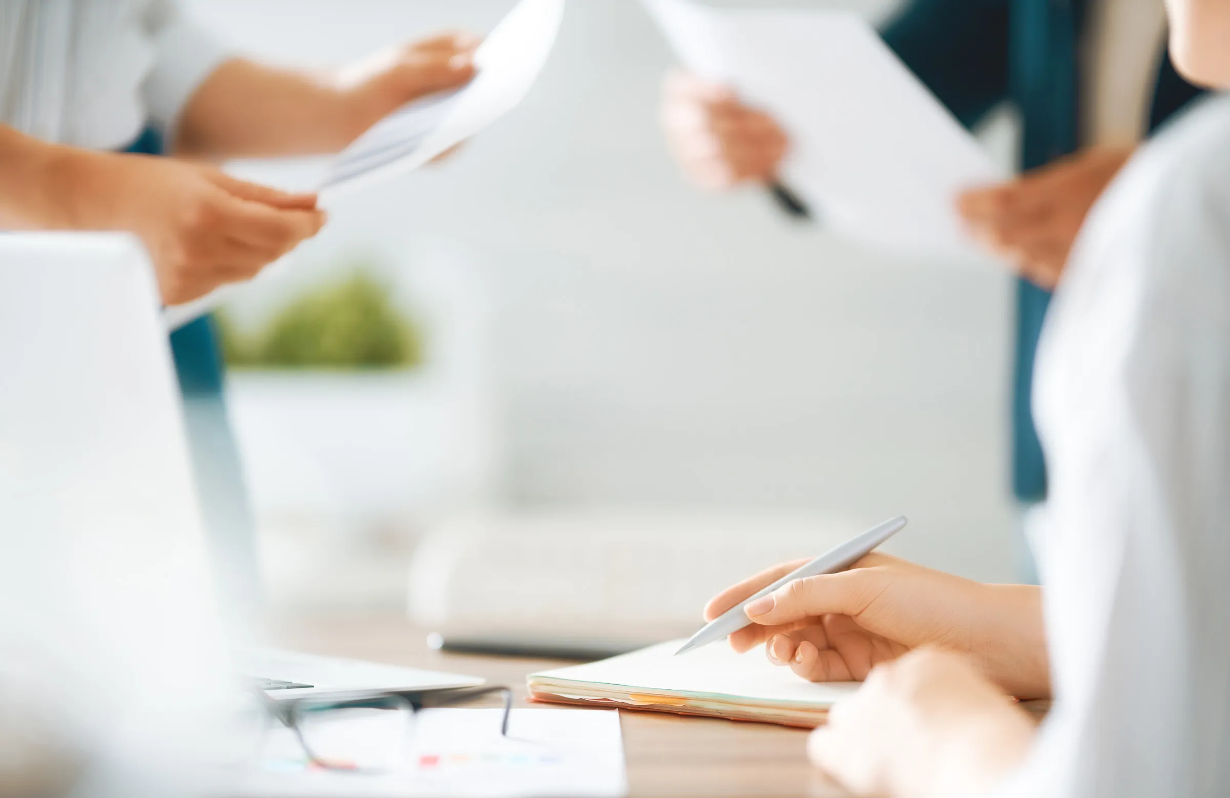 Componenti di una commissione che esaminano documenti e prendono appunti attorno a una scrivania